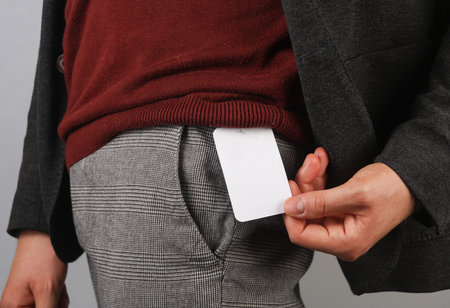 Man holds white paper tag on his pants. Sale concept