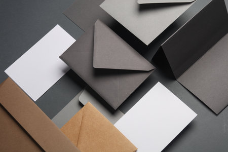 Floating envelopes and cards on dark gray background with shadow. Minimalism, modern business still life, creative layoutの写真素材