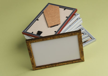 Stack of photo frames on green background