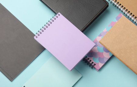 Composition of floating notepads on a blue background