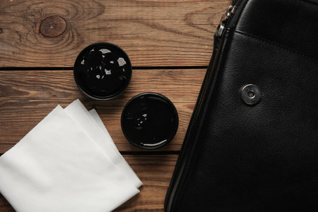 Leather care products and briefcase on wooden backgroundの写真素材