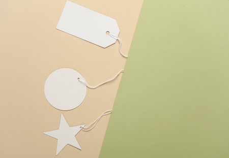 White blank tags with string on beige green backgroundの写真素材