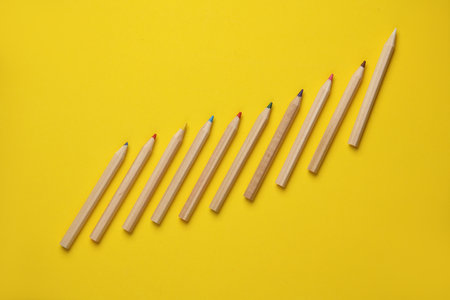 Set of wooden colored pencils on yellow background. Creativity, art