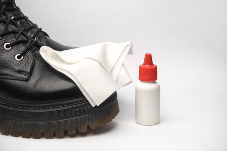 Leather boots and a rag on a white background. Shoe care. Polishing, glossingの写真素材