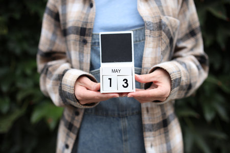 Woman holds calendar with the date May 13 outdoors.の写真素材