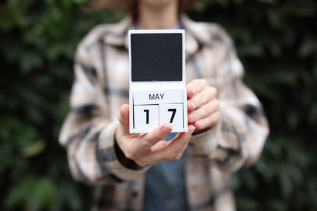 Woman holds calendar with the date May 17 outdoors.の写真素材
