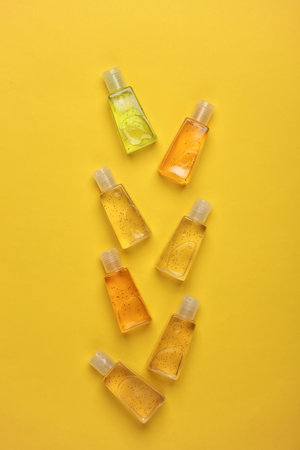 Antiseptic bottles on yellow background. Top viewの写真素材