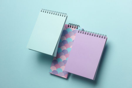 Composition of floating notepads on a blue background