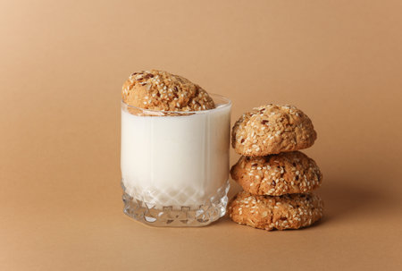 Yogurt in glass and cereal cookies on brown backgroundの写真素材