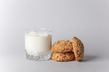 Yogurt in glass and cereal cookies on gray backgroundの写真素材