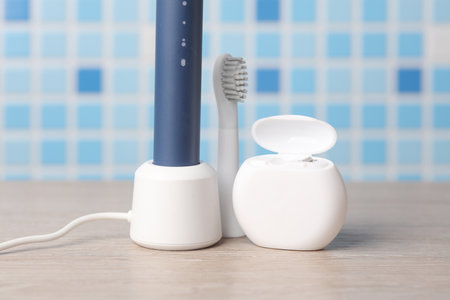 Modern smart ultrasonic toothbrush with dental floss on the tableの写真素材