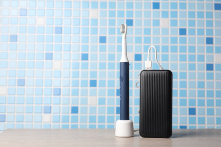 Modern smart ultrasonic toothbrush charging with power bank on the tableの写真素材