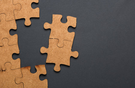 Wooden pieces jigsaw puzzle on dark gray background