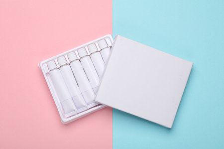 Set of white empty tubes of acrylic or oil paint for creativity on pink blue background. Template...