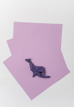 Purple paper origami dragon on white backgroundの写真素材