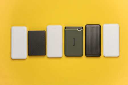 Power banks and external hard drives on a yellow backgroundの写真素材