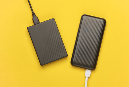 Power bank and external hard drive on a yellow background