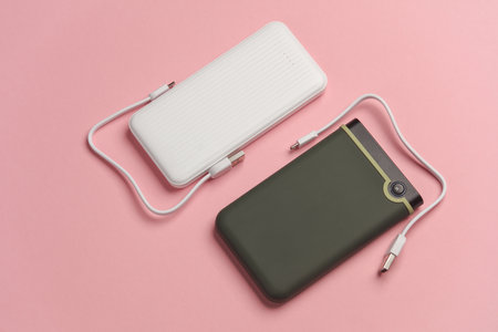 Power bank and external hard drive on a pink background