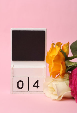 White Wooden calendar mockup with date 04 without month on pink background with flowersの写真素材