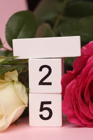 White Wooden calendar mockup with date 25 without month on pink background with flowers