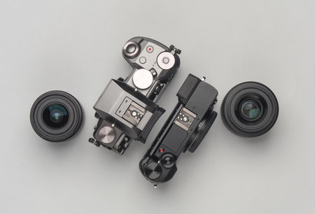 Two modern digital mirrorless cameras with lenses on a gray background. Top viewの写真素材