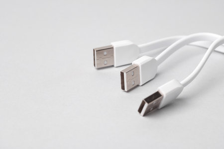 Three white USB cables on a gray backgroundの写真素材