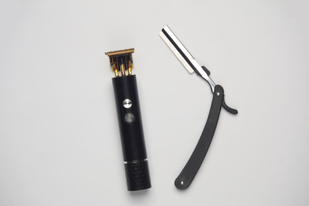 Hair straightener and razor on white background. Top view.