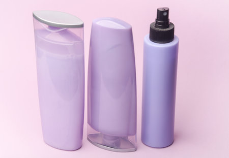 Shampoo and spray bottles on purple pastel backgroundの写真素材