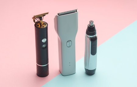 Trimmers and hair clipper on a blue-pink background.