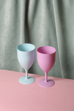 Colored Plastic glasses against the background of a curtain. Aesthetic still life. Minimalism. Holiday, party moodの写真素材