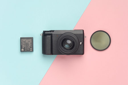 Modern mirrorless camera with accessories on a blue-pink background. Professional photographer equipment. Top view. Flat layの写真素材