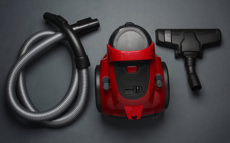 Red vacuum cleaner on a dark background. Top viewの写真素材
