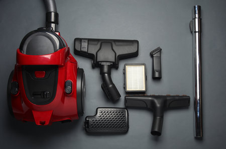 Components and attachments of a modern vacuum cleaner on dark background. Top view. Flat layの写真素材