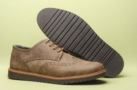 Leather brogue shoes on green background