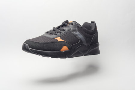 Black Sport sneaker floating on gray background