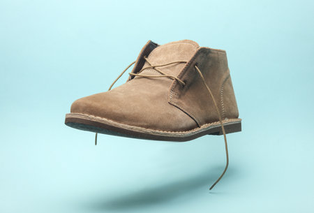 Desert shoe floating on blue background