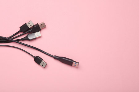 Lots of USB cables on a pink background