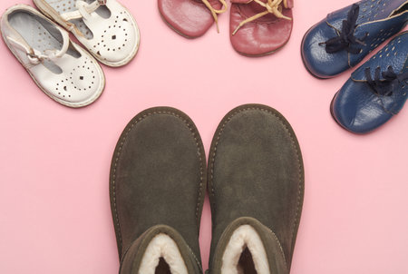 Mother's and child's shoes on a blue-pink background. Top view