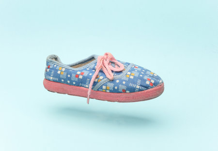 Children's shoe floating on blue backgroundの写真素材