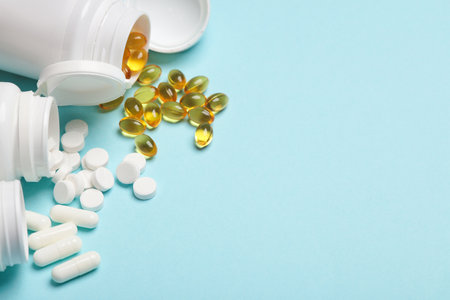 Different Pills in plastic bottles on blue background. Medicine concept. Copy space