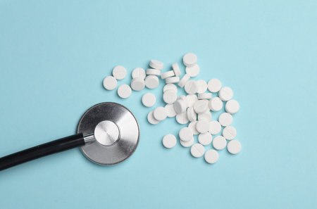 Stethoscope with pills on blue backgroundの写真素材