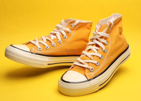 Old school rubber shoes on a yellow backgroundの写真素材