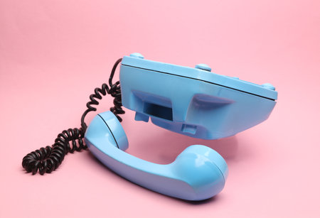 Blue retro rotary phone floating on pink backgroundの写真素材