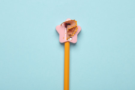 Pencil with sharpener on blue background