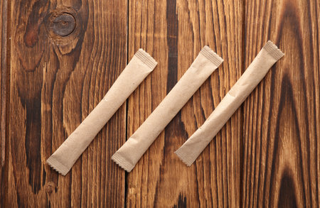 Packages of single-serve coffee or sugar on wooden backgroundの写真素材