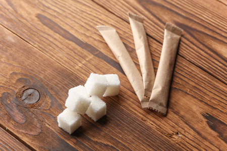 Packaging of single-serve coffee and sugar cubes on wooden backgroundの写真素材