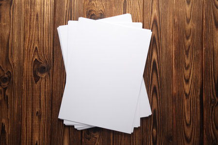 White blank sheets of A4 paper on wooden boards. Mockup for design