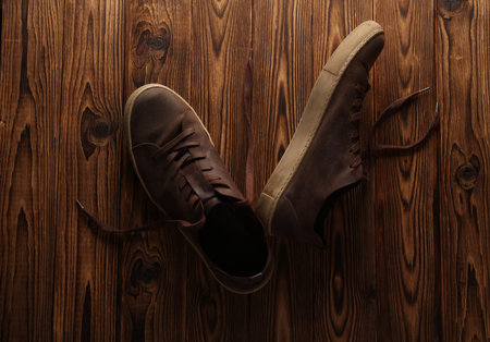 Used leather sneakers on a wooden backgroundの写真素材