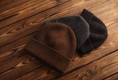 Various winter hats on a wooden background. Top view
