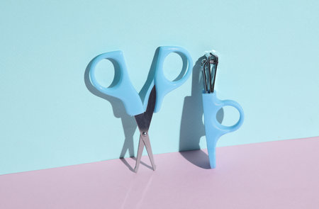 Scissors and tweeters on a blue-pink background.の写真素材